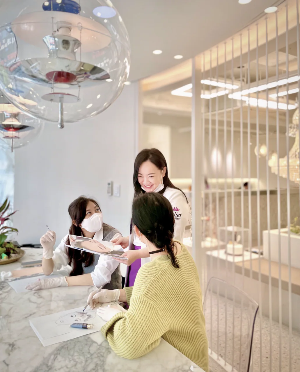 흰 세로 살 칸막이와 샹들리에가 보이는 공간에서 웃는 대표원장